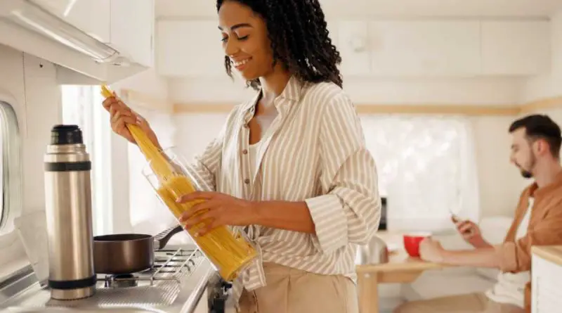 jeune fille cuisons des pates dans un van